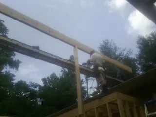 Carpenter setting a ridge beam over a new addition frame — Ice Dam Removal by Roofing Brothers in Larkspur